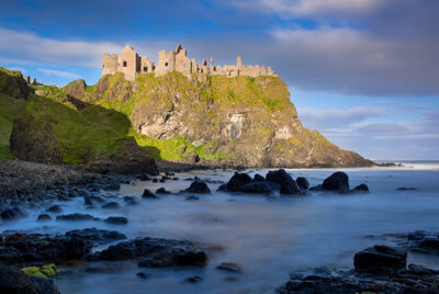 Sunrise over Dunluce Castle along northern coast of County Antrim, Northern Ireland.